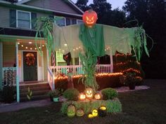 a house decorated for halloween with pumpkins and lights