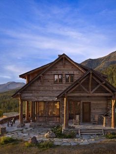 a rustic log cabin sits in the mountains