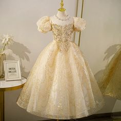 This stunning Princess Jewel Neck Floor Length Sequined Flower Girl Dress in Gold is perfect for any special occasion, from weddings to holidays. The intricate beaded and sequined embellishments add a touch of elegance, while the puff sleeves and crossed straps provide a comfortable and stylish fit. Make your little one shine in this beautiful dress. Gold Girls Dress, Junior Pageant Dresses, Girls Gold Dress, Princess Dress Up, Girls Pageant Dresses, Gold Girl, Princess Gown, Princess Ball Gowns, Pageant Dress