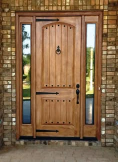 a wooden door with glass and brick wall