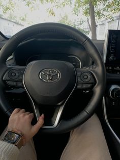 a person is sitting in the driver's seat of a car with their hands on the steering wheel