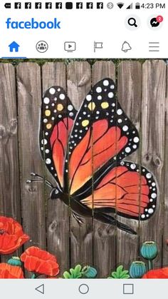 a painting of a butterfly on a fence with red poppies in the foreground