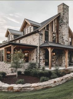 a large stone house sitting on top of a lush green field