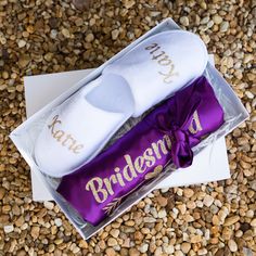 two bridesmaid socks in a gift box on top of some pebbles