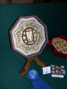 an umbrella and other items on a green cloth covered table with a blue ribbon around it