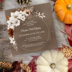 the wedding card is surrounded by fall leaves and pumpkins, including one with flowers on it