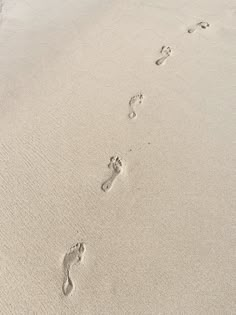 the footprints of two people are in the sand