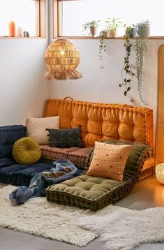 a living room filled with lots of furniture and pillows on top of a white rug