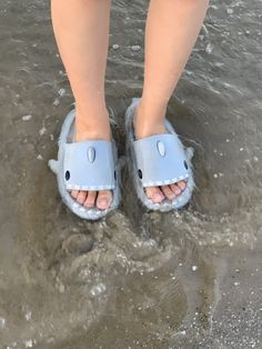 a person standing in the water wearing blue slippers