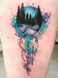 a woman's thigh with trees and mountains on it