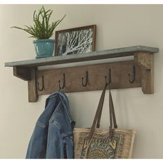 a coat rack with two coats hanging from it's sides and a purse on the other side