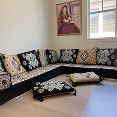 a living room filled with lots of furniture and pillows on top of it's floor