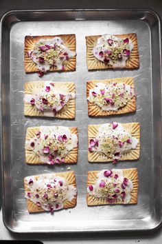 six crackers with various toppings sitting on a baking sheet