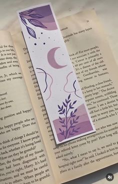 an open book with a purple and white bookmark