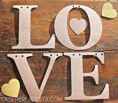 the word love spelled with cut out hearts on a wooden background for valentine's day