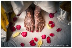 the feet of a bride with henna and petals on the floor at their wedding