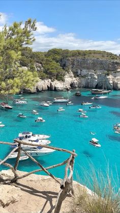 many boats are in the water near some rocks