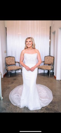 a woman in a white wedding dress posing for a photo with her hands on her hips