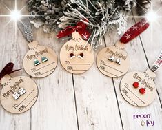 three wooden christmas ornament hanging from a tree on a white wood floor with snowflakes