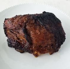 a piece of meat sitting on top of a white plate