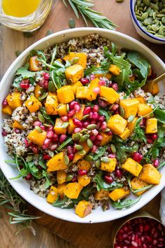 a white bowl filled with salad and topped with pomegranates