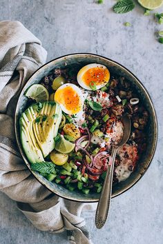 an overhead view of a bowl with eggs, beans, avocado and onions