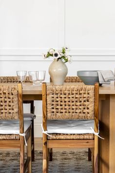 a table with chairs and a vase filled with flowers