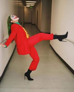 a woman dressed as the joker is leaning against a wall