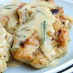 chicken covered in gravy on a white plate