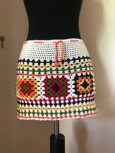 a crocheted skirt is displayed on a mannequin's head stand