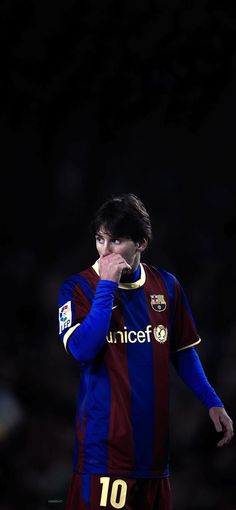 a man in a blue and red uniform talking on a cell phone while holding his hand to his face