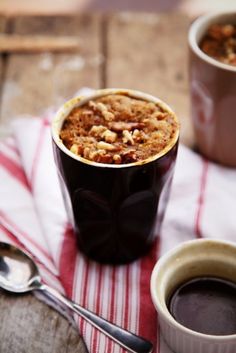 two cups of coffee and spoons on a table