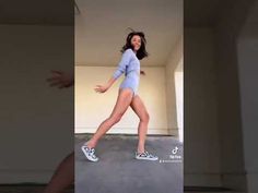 a woman is dancing in the middle of an empty room with her legs spread out