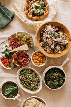 several bowls of food are arranged on a table