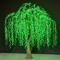 a lighted tree with green leaves on it's branches is shown in front of a black background