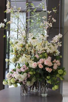 two vases filled with flowers on top of a table