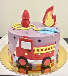 a birthday cake with a fire truck on it's side and a fire hydrant on top