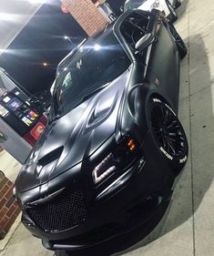 a black sports car is parked on the street