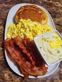 the plate has eggs, pancakes and bacon on it