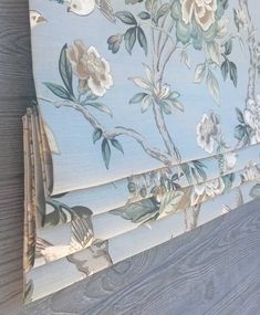 a close up of a flowered roman blind with birds on it's side