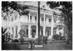 an old black and white photo of people in front of a house