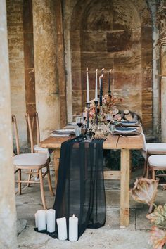 the table is set with candles and flowers for an elegant dinner or reception at home