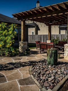 an outdoor patio with stone and wood furniture