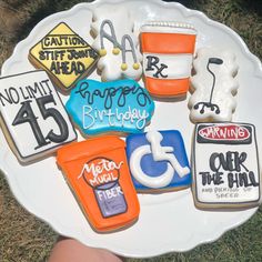 decorated cookies sitting on top of a white plate in the shape of numbers and signs