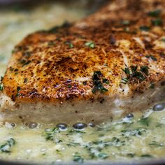 a piece of meat is being cooked in a skillet