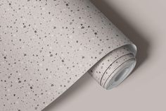 a white wallpaper with grey speckles on the bottom and gray background behind it