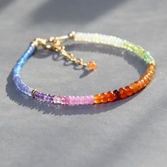 So fun and colorful this dainty beaded bracelet features melange of gems in rainbow hues. From one end to the other the gems used are: blue topaz, tanzanite, amethyst, pink sapphire, carnelian, garnet,  spessonite orange garnet, Ethiopian opal, citrine, peridot and arranged in sections. Made adjustable from7.25 to 8.5 inches.   Great on its own or layered with other gemstone bracelets. Awesome gift! gems  from 2 -3.5mm Thank you for looking! Please contact me if you have any questions or request Stacking Jewelry, Orchid Jewelry, Nugget Bracelet, Ruby Bracelet, Rainbow Gemstones, Labradorite Bracelet, Dainty Bracelet, Jewelry Beaded, Stacked Jewelry