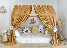 a canopy bed with curtains and flowers on the bottom is in a room that has wood flooring