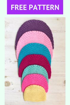 a pile of knitted hats sitting on top of a white wooden floor next to each other