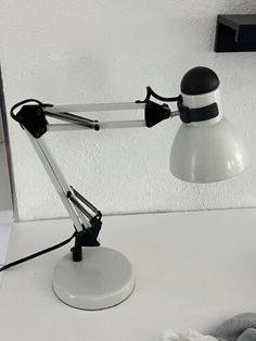 a desk lamp sitting on top of a white table